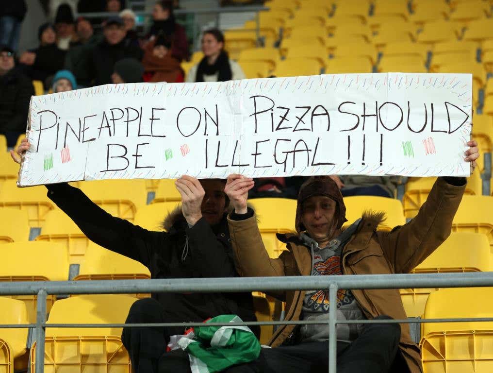 Fans hold a banner reading 'pineapple on pizza should be illegal!' prior to the FIFA Women's World Cup