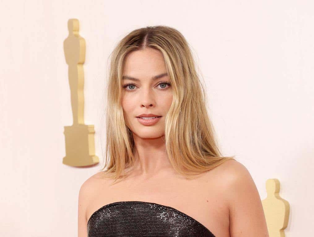 Margot Robbie attends the 96th Annual Academy Awards wearing a strapless black gown for the 2024 oscars best dressed women.