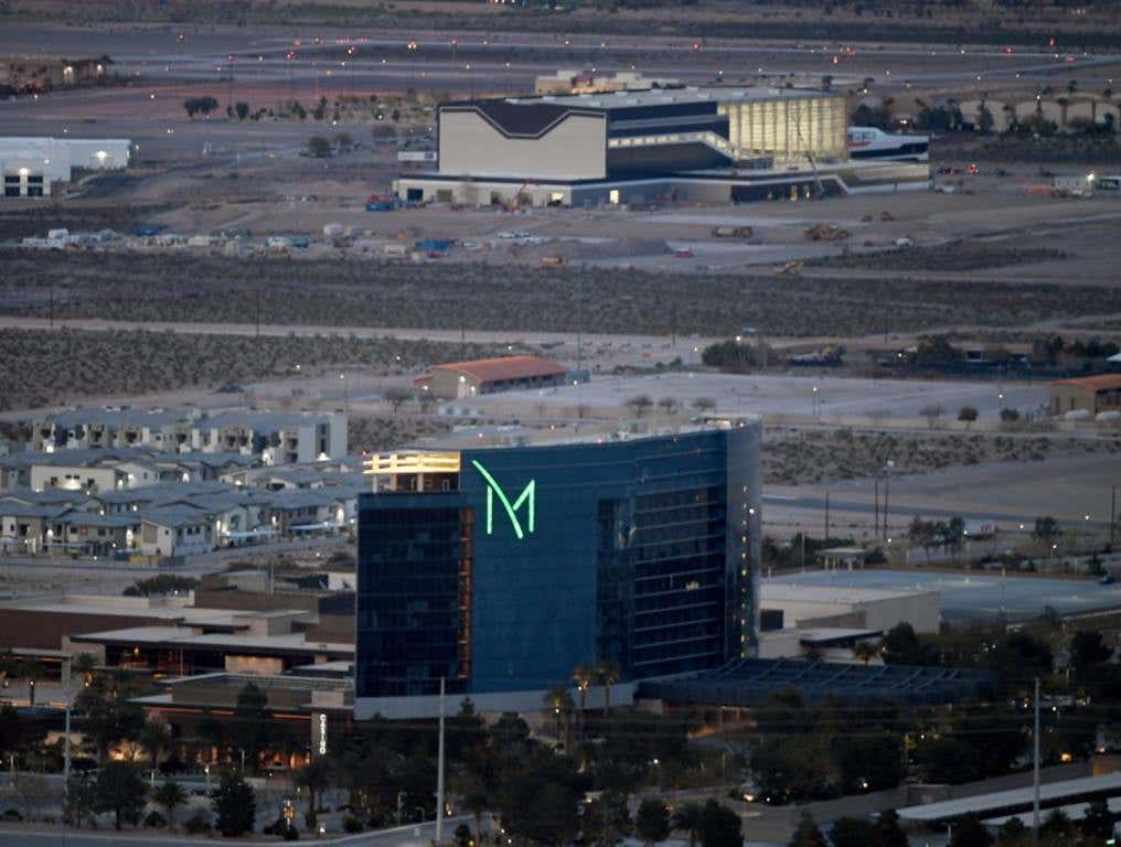 The fabulous M Resort Pool will be the site of three Dive-In Movie Nights. A general view of the M Resort on the southern end of the Las Vegas Strip at dusk. The mostly blue glass building has a large, bright green "M" logo on the front. There are homes and an industrial complex visible in the background.