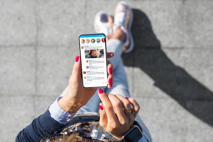 Woman using social media microblogging app on her smart phone